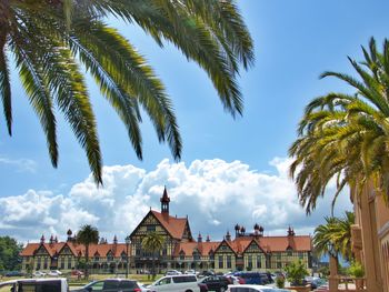 Panoramic view of palm trees and houses against sky