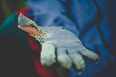 Midsection of person wearing torn glove