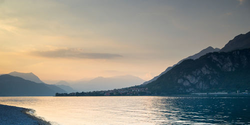 Scenic view of sea and mountains against sky during sunset