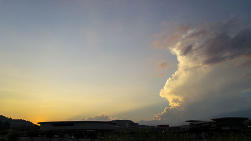 Cars on road against sky at sunset