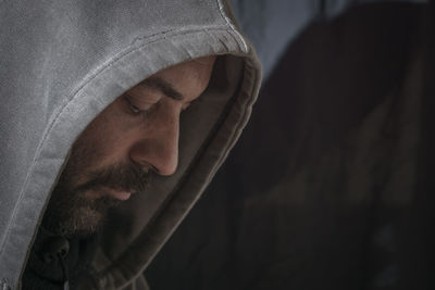 Close-up of man wearing hood clothing in darkroom