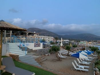 Buildings by sea against sky