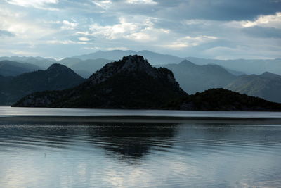 Scenic view of lake against cloudy sky