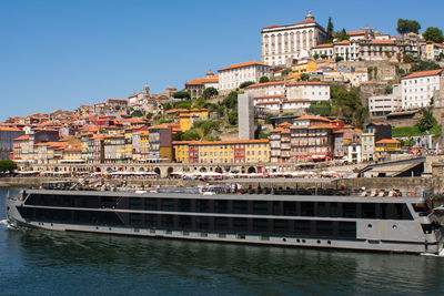 River amidst buildings in city against clear sky