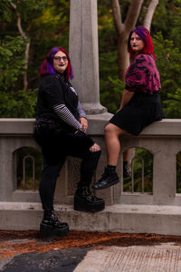 Full length of friends sitting on staircase