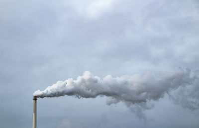 Smoke emitting from chimney against sky