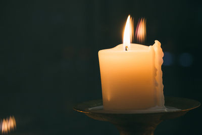 Close-up of burning candle in darkroom