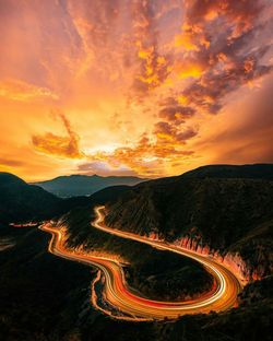 Aerial view of dramatic landscape against sky at sunset