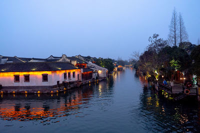 River amidst houses and buildings against sky