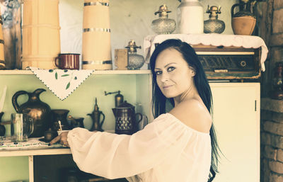 Portrait of young woman standing at home