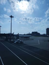 Airplane on airport runway against sky