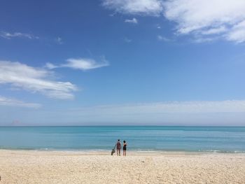 People on beach against sky