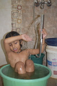 Full length of shirtless boy in bathroom at home