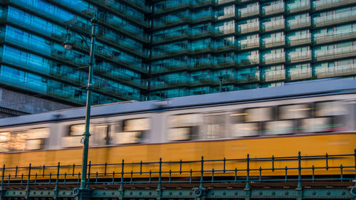 Blurred motion of train against building in city 