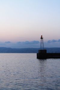Silhouette ship in sea against sky during sunset