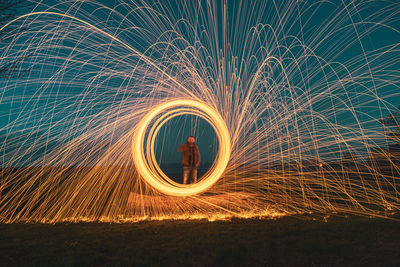 Low angle view of illuminated lighting equipment at night