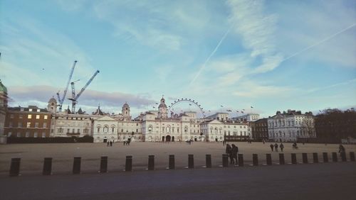 Buildings in city against cloudy sky