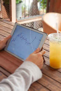 Midsection of man using mobile phone on table