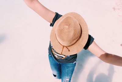 Midsection of woman holding hat