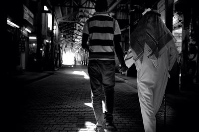 Full length of woman standing in illuminated city at night