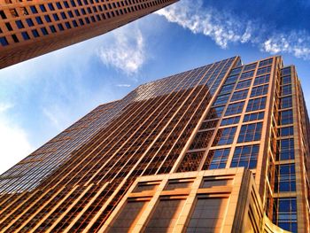 Low angle view of modern building against cloudy sky