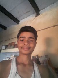 Portrait of smiling young man standing at home