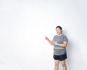 Portrait of smiling man standing against white background