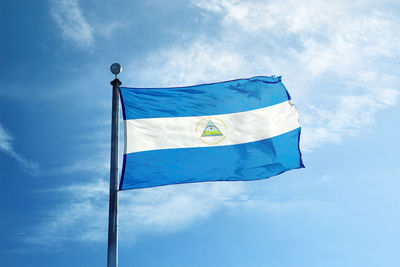 Low angle view of flag against blue sky