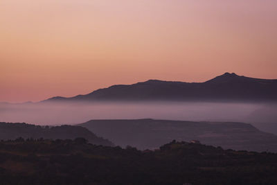 Scenic view of silhouette mountains against sky during sunset