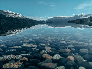 Scenic view of lake and snowcapped mountains against sky