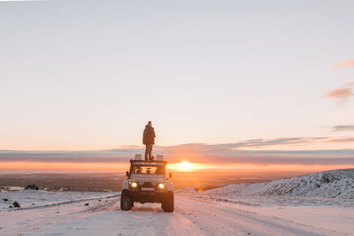 Scenic view of snow on field against sky during sunset