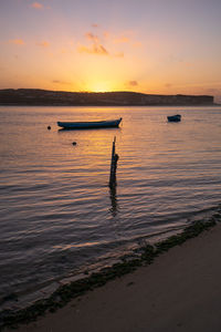 Fishing boats on a river sea at sunset in foz do arelho, portugal