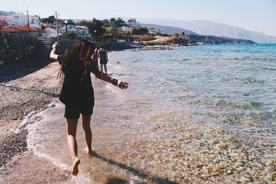 Girl jumping on shore at beach