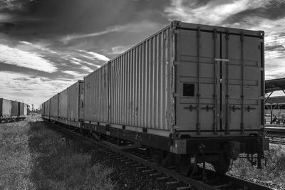 View of freight train against cloudy sky