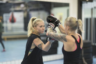 Two women practicing martial arts at gym