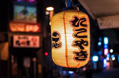 Close-up of illuminated japanese lantern hanging outdoors at night