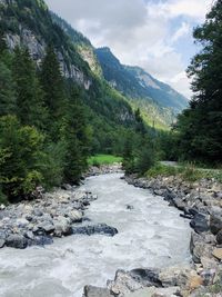 River flowing amidst mountains against sky