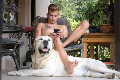 Young man communicates on his mobile phone on the terrace at hom