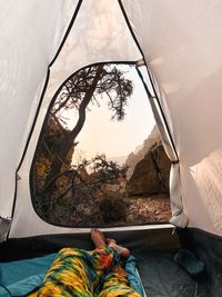 Low section of man relaxing in tent