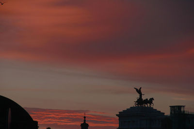 Low angle view of silhouette statue against cloudy sky