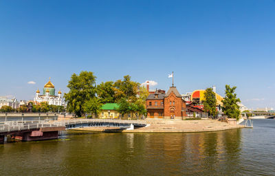 River passing through buildings against sky