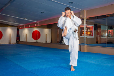 Karate man is preparing to do a kick called "mae geri"
