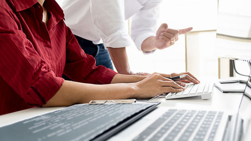 Rear view of man using laptop on table