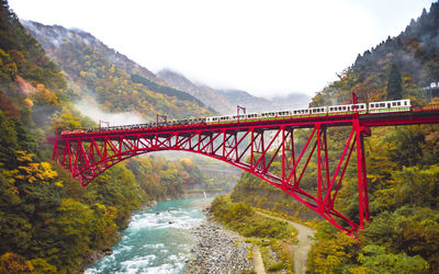 Bridge over river against sky during autumn