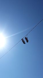 Low angle view of overhead cable against clear blue sky