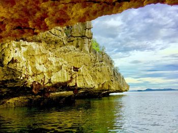 Scenic view of rock formation in sea against sky
