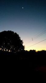 Silhouette trees against clear sky during sunset