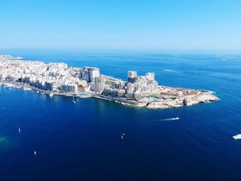 High angle view of cityscape by sea against sky