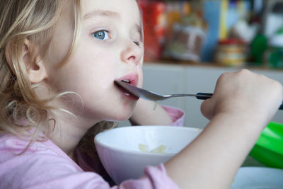 Close-up portrait of baby girl holding bowl