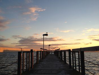 Pier on sea at sunset